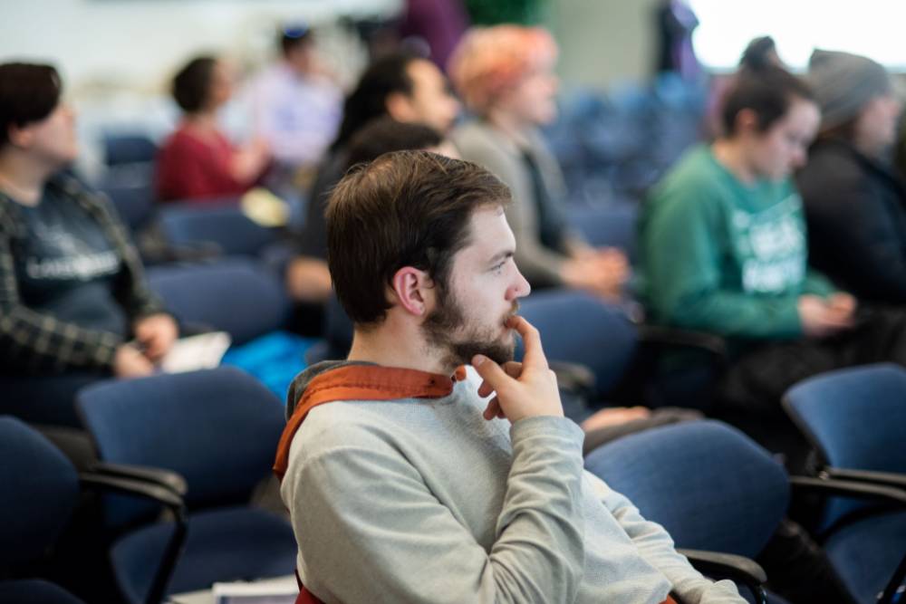 A student listens intently to a faculty member's presentation.